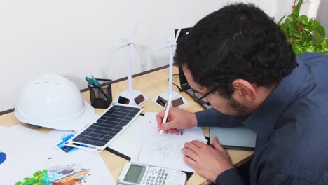 architect drawing a technical design for a green energy project