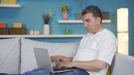 hombre usando computadora portátil con expresión feliz y satisfecha.
