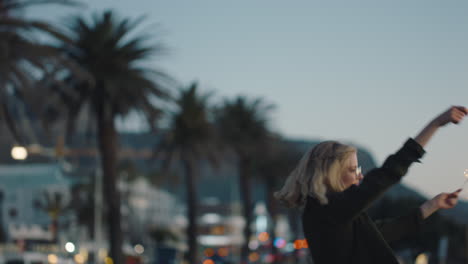 Junge-Frau-Tanzt-Mit-Wunderkerzen-Am-Strand-Bei-Sonnenuntergang-Und-Feiert-Silvester,-Feiert-Den-Unabhängigkeitstag-Mit-Feuerwerk-Und-Genießt-Die-Freiheit