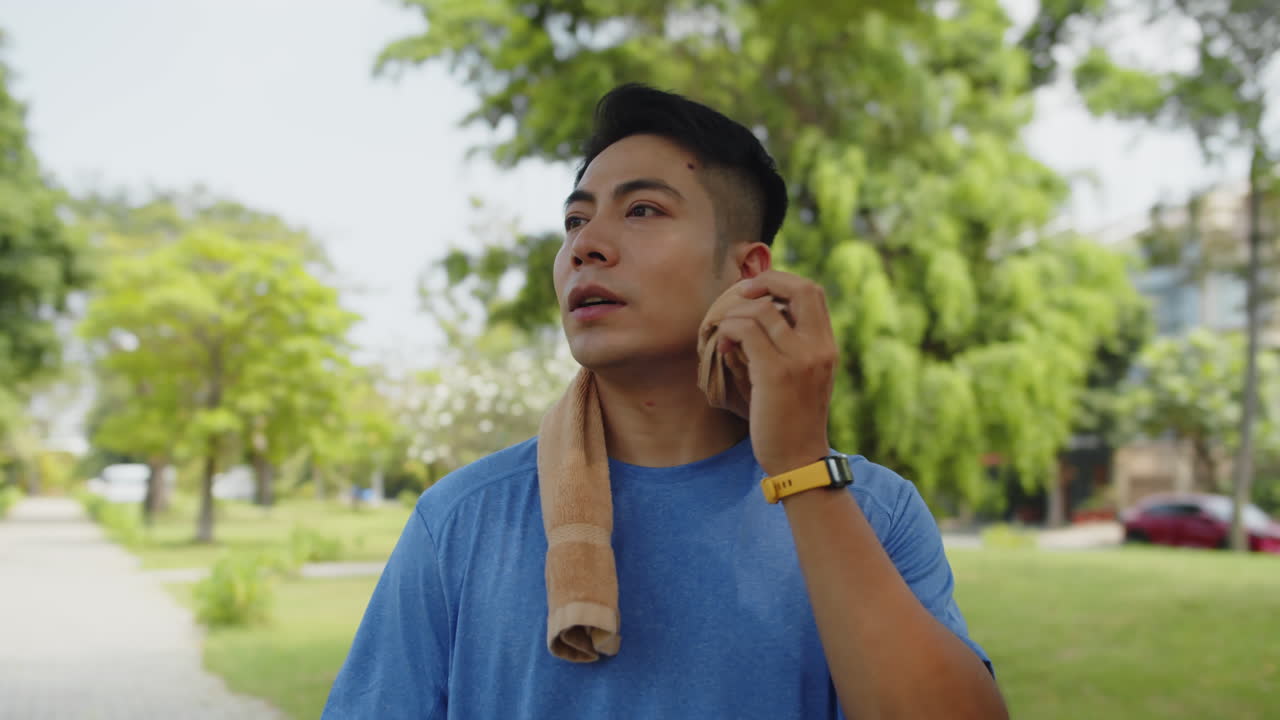 Male Athlete Wiping Face with Towel after Morning Training