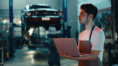 mechanic using laptop in garage