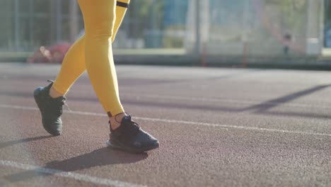 woman jogging on outdoor track in sportswear at athletic field