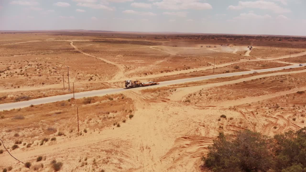 큰 트럭이 도로를 운전하는 동안 사막의 빈 도로의 공중 전망