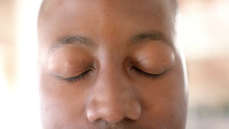 portrait of happy african american casual businessman opening eyes in creative office in slow motion