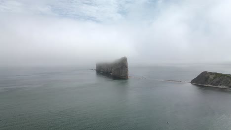 formación rocosa perce por el golfo de san lorenzo en un día de niebla en quebec, canadá