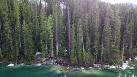 panning left drone shot of the rocky alpine coast of colchuck lake and forest, near the enchantments in washington's cascade mountain range