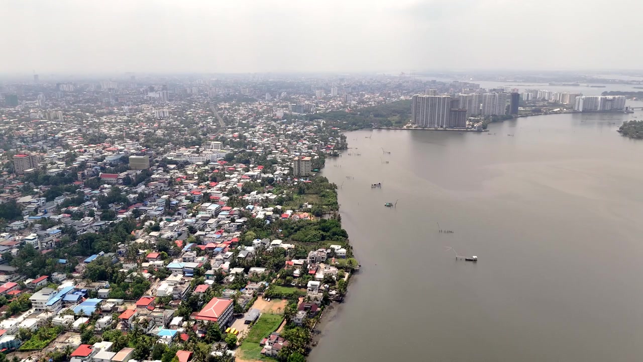 Video drone del paesaggio urbano di Ayyappankavu che presenta vivaci comunità fluviali, tranquilli corsi d'acqua interni e uno skyline sorprendente di complessi di appartamenti contemporanei che si fondono con il verde tropicale