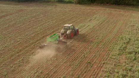 close follow aerial shot of a tractor ploughing a field