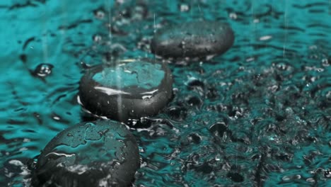 raindrops falling in green water and on black stones.