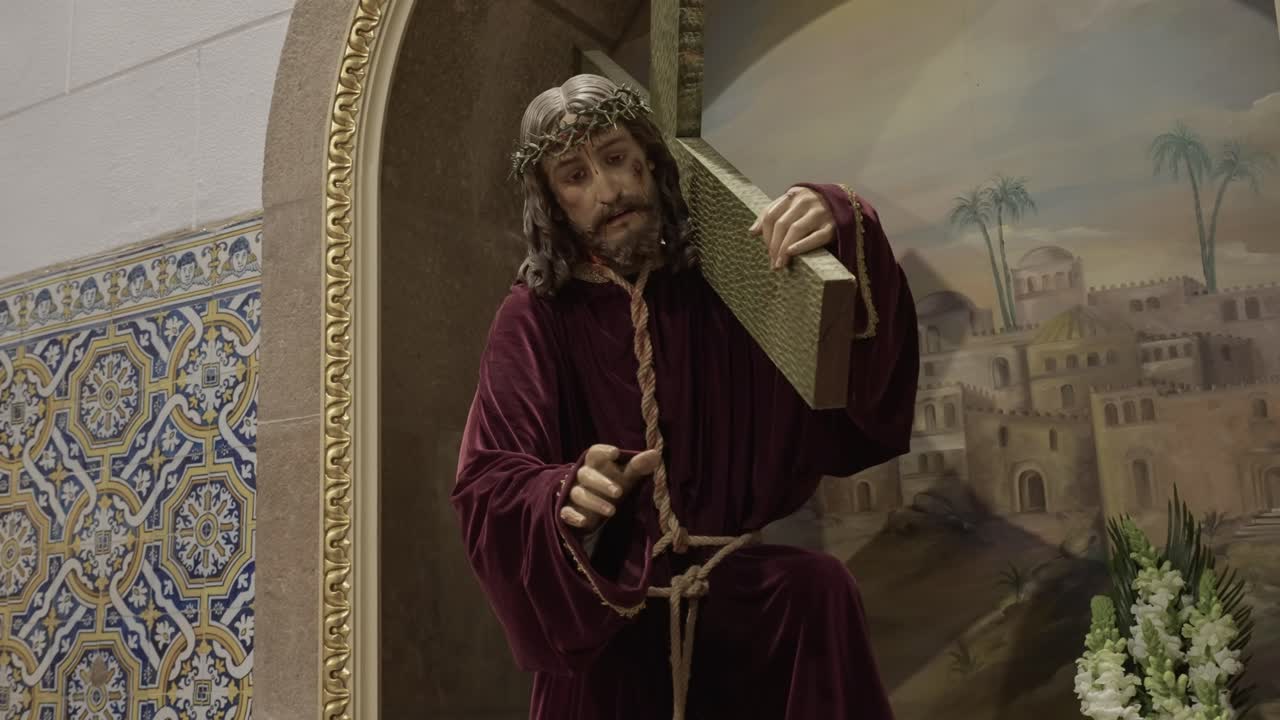 Scultura religiosa di Gesù con la croce esposta in chiesa.