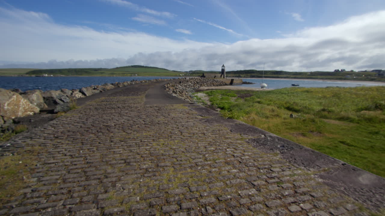 extra wide shot off the stone road leading onto port Logan harbour