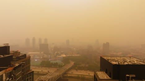 wildfire haze covering new york, usa - flying past high-rise, toward the east harlem cityscape - aerial view