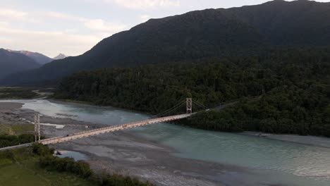 Cars-crossing-incredibly-picturesque-bridge-over-melted-glacier-water,-aerial