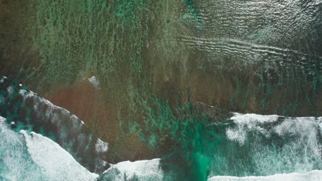 Aerial-view-of-waves-crashing-over-reef-in-Kauai,-Hawaii