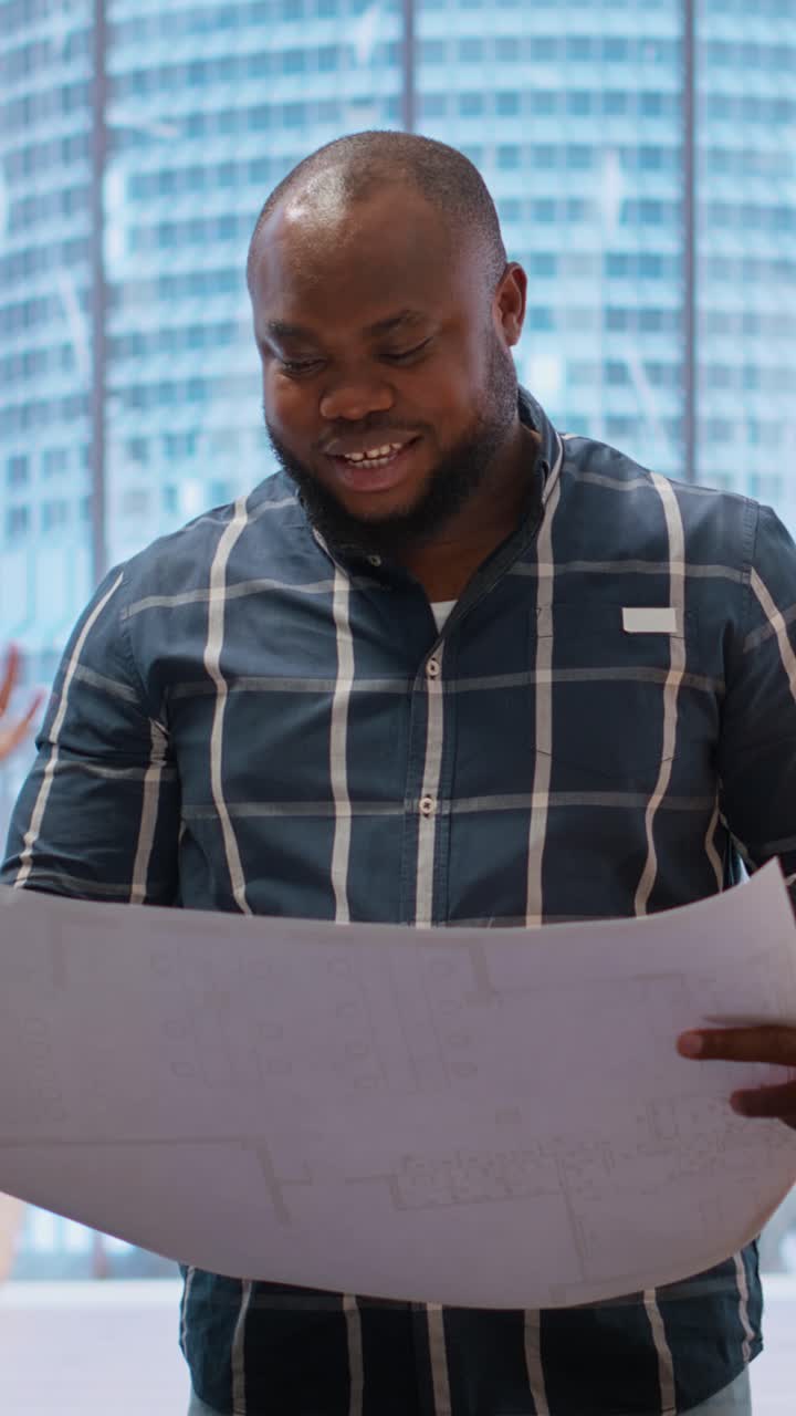 African American Architect Discussing Blueprints in Modern Office