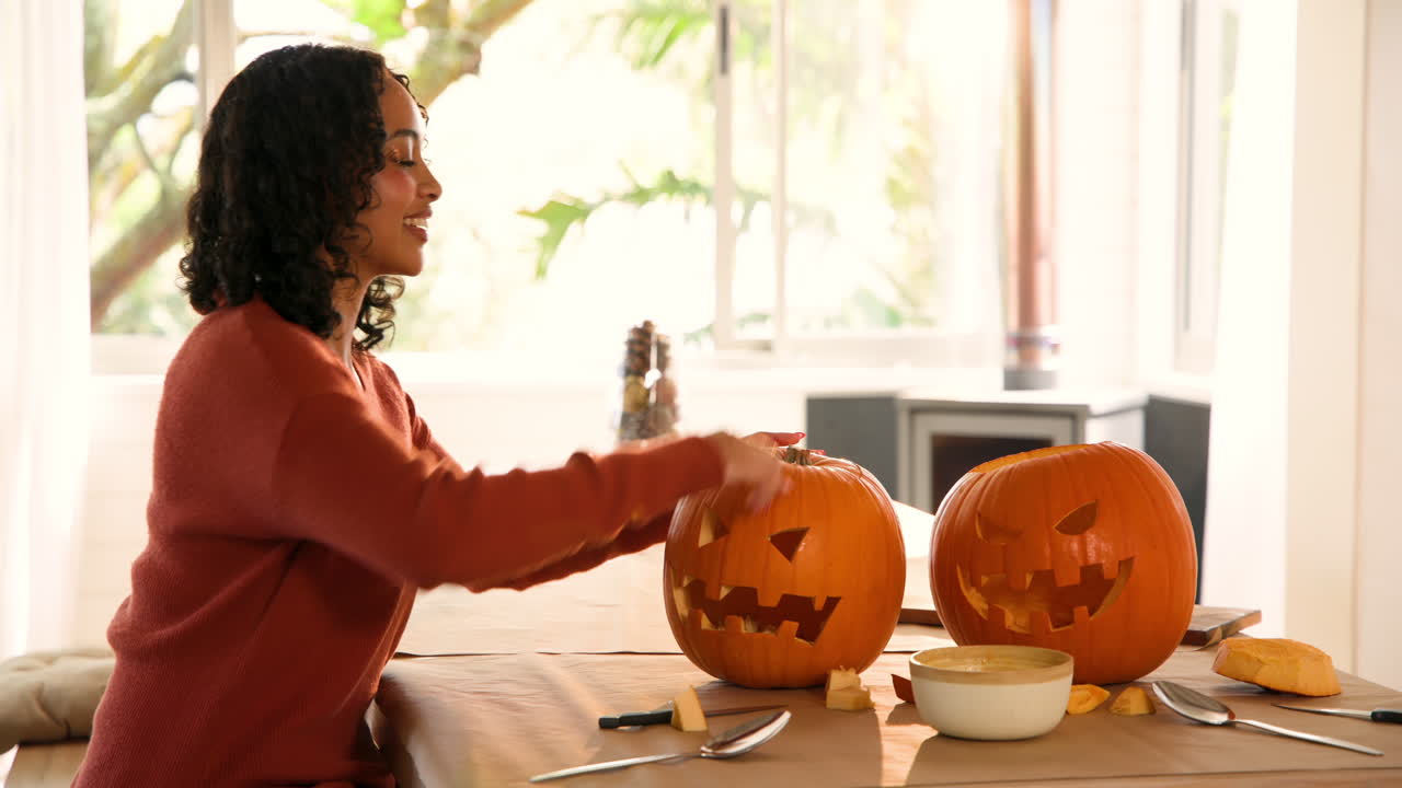 Halloween time, Carving pumpkins, woman preparing festive decoration at home