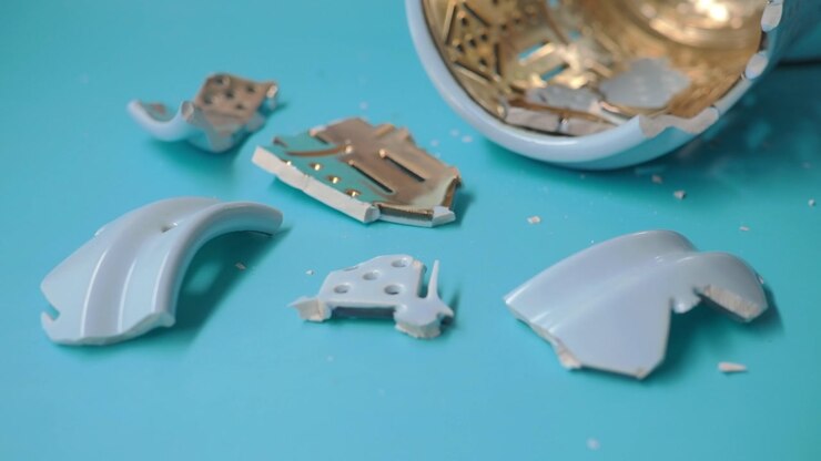 Shattered Light Blue Ceramic Pieces on a Turquoise Surface