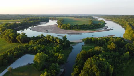 drone footage panning and raising altitude while viewing a horseshoe bend in a river at sunset