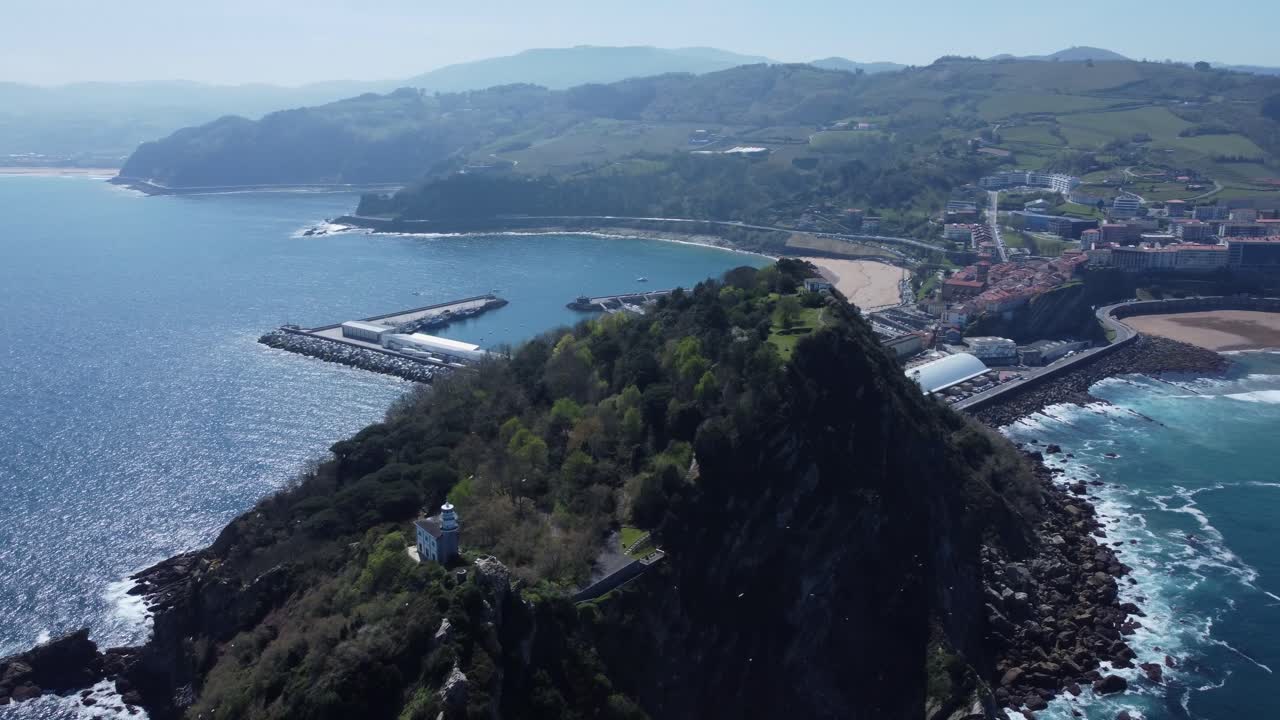 las aves vuelan en el sol de la mañana en el faro de getaria en el norte de españa