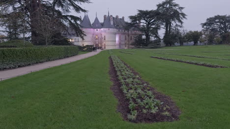 a historic castle in chaumont-sur-loire with manicured gardens and towering trees at dusk