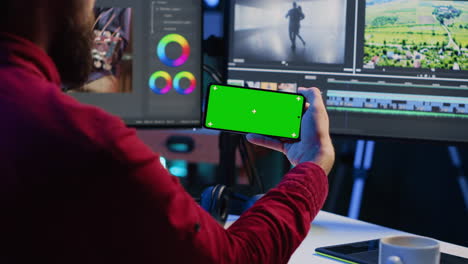 Video-editor-watching-tutorial-on-mockup-phone-about-editing-color-grading-and-lighting