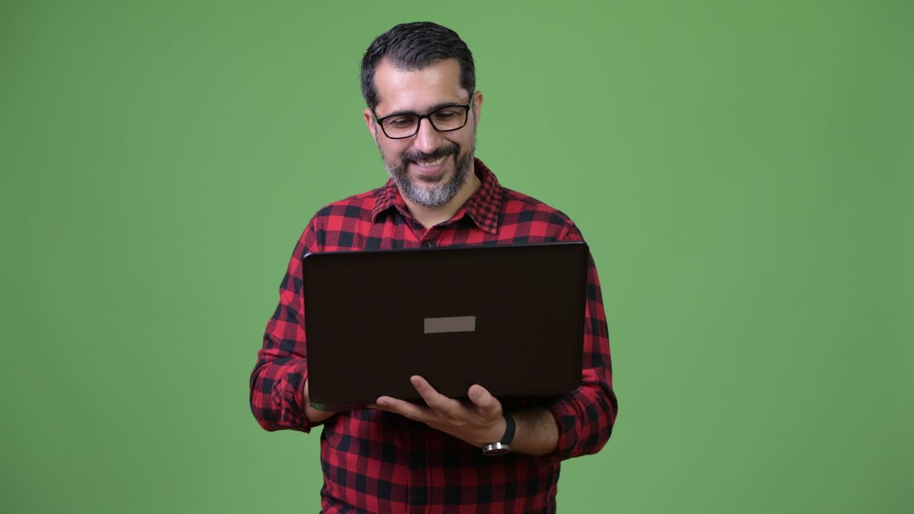 Handsome Persian bearded man using laptop