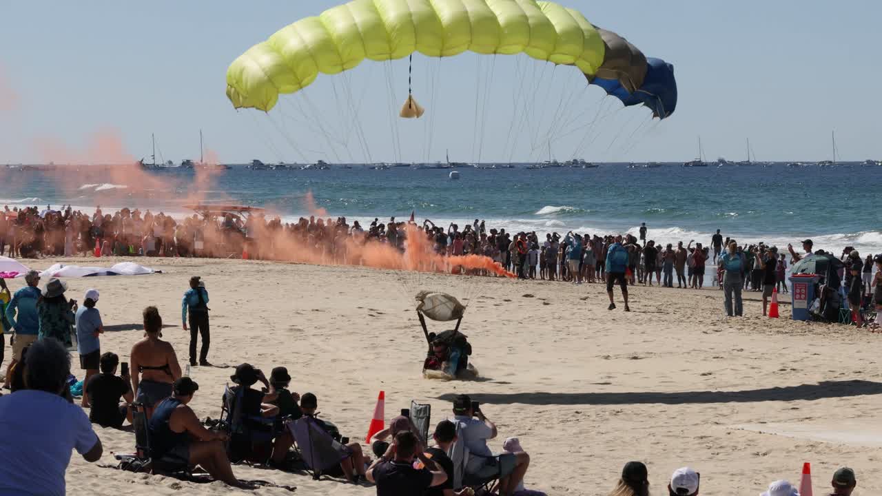 парашютисты приземляются среди зрителей на солнечном пляже