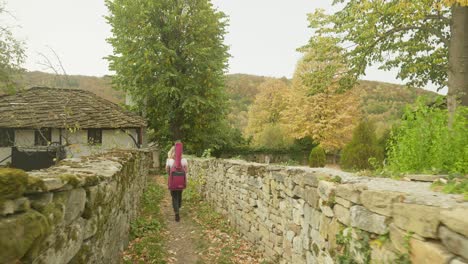 una joven músico feliz explora la calle de la aldea amurallada escena de otoño