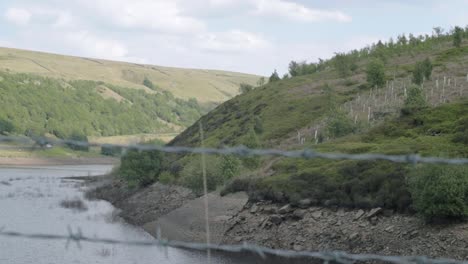 butterley reservoir and yorkshire hills wide tilting shot through fence