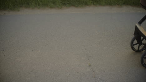 closeup of baby stroller wheels on asphalt