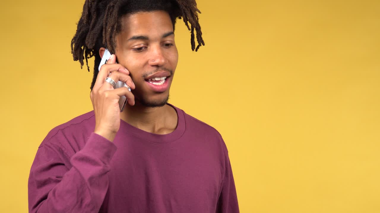 A cheerful, handsome black male student received good news on his phone call and smiling