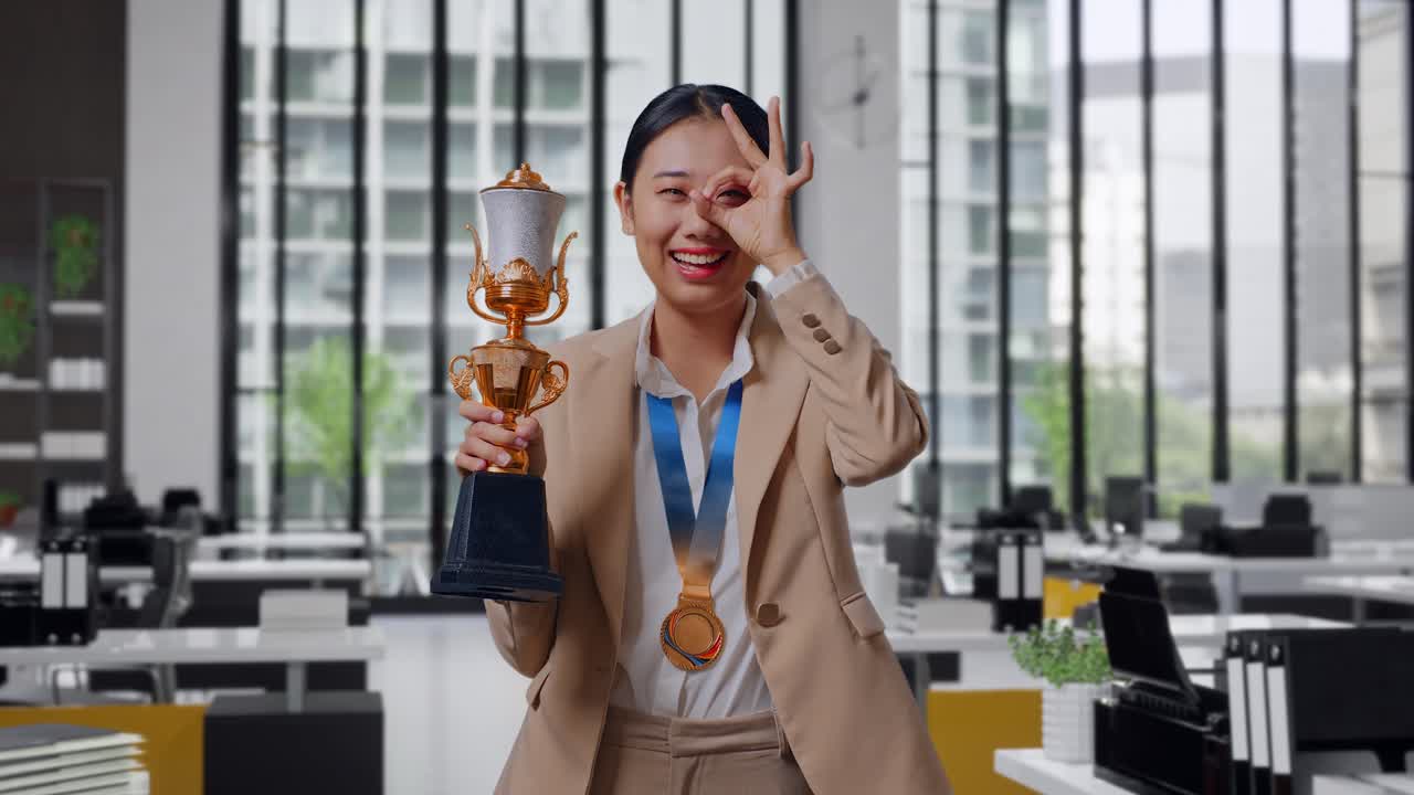 Asian Business Woman In A Suit With A Gold Medal And Trophy Showing ...
