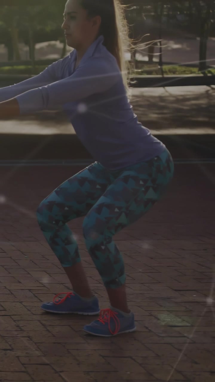 Video verticale: Donna che sposta il peso mantenendo uno squat basso su un mattone per il fitness, linee luminose intatte.
