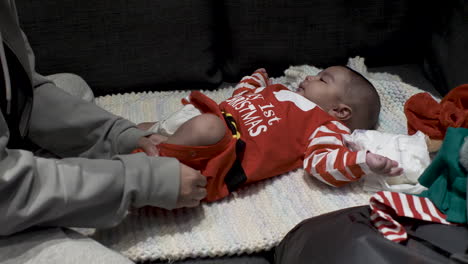 Cute-3-Month-Old-Baby-Wearing-Red-My-1st-Christmas-Outfit-Laid-On-Blanket-Getting-A-Nappy-Change