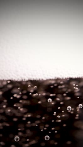 carbonated beverage with rising bubbles and foam