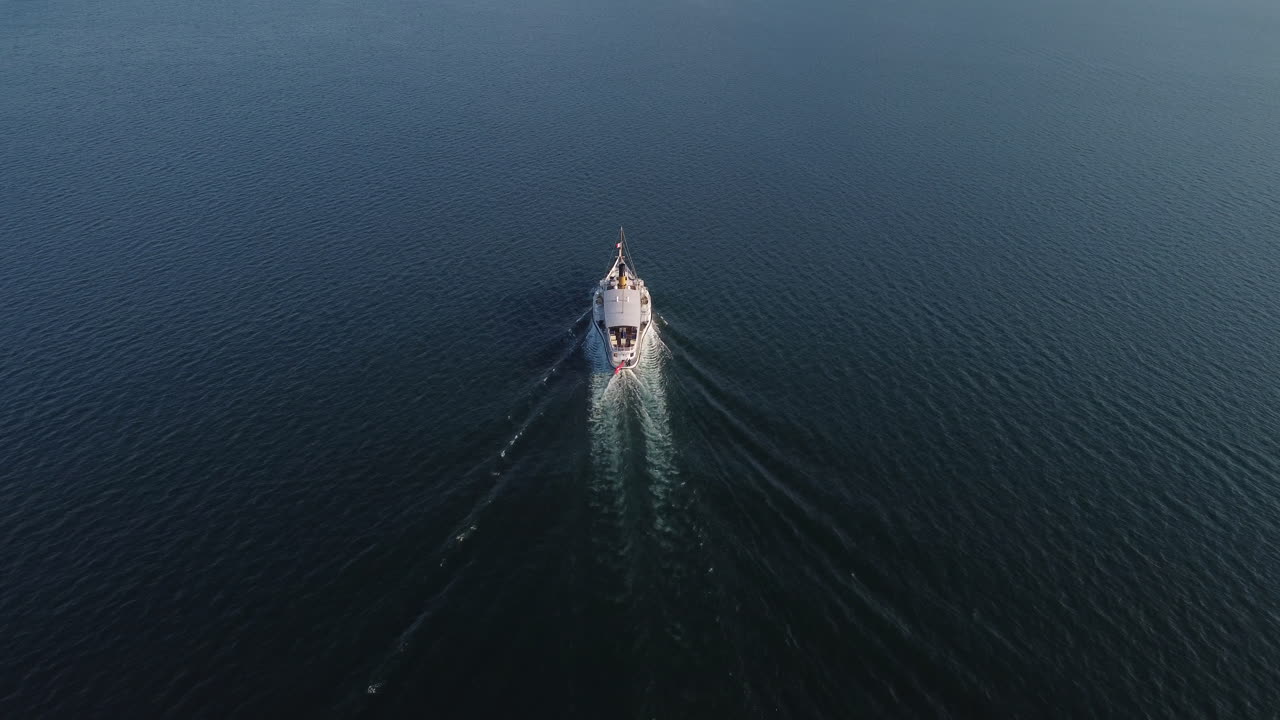Slow aerial tilt down shot of a ferry boat on Lake Geneva near Vevey, Switzerland