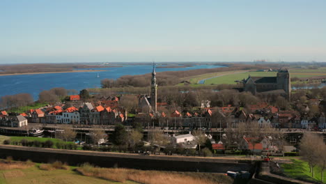 Aerial:-The-historical-town-of-Veere-with-an-old-harbour-and-churches,-on-a-spring-day