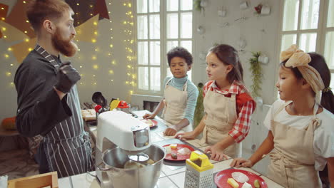 Chef-Respondiendo-Preguntas-De-Los-Niños-Durante-La-Clase-Magistral-De-Cocina