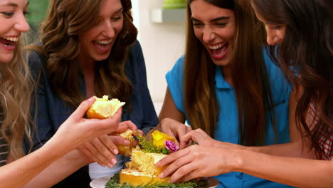 amigos sonrientes comiendo pastel