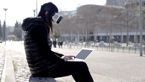 young woman in vr headset using laptop