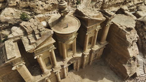 aerial view away from a nabatean arab on top of the el-deir in petra, jordan - pull back, tilt, drone shot