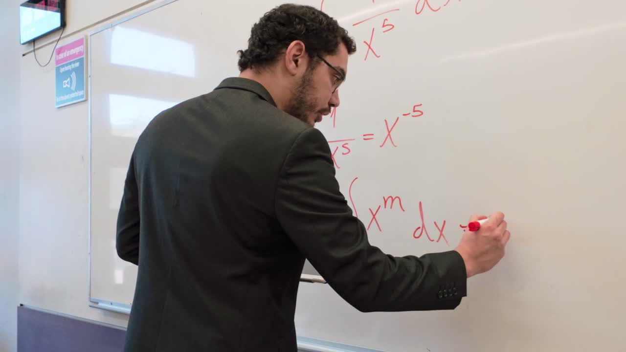 Man Writing an Integral Formula with a Marker