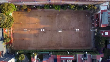 top down shot flying away from a beautiful tennis sports club in the morning in mexico city