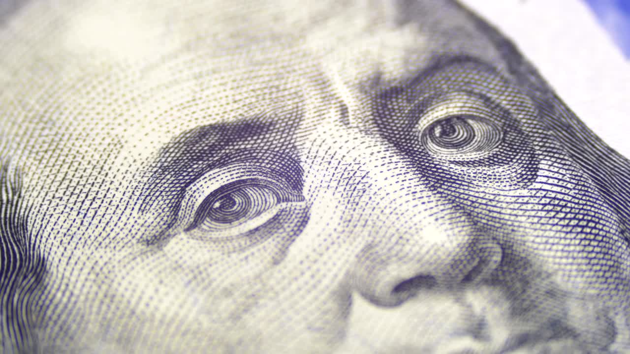 el retrato del presidente benjamin franklin en un billete de cien dólares gira