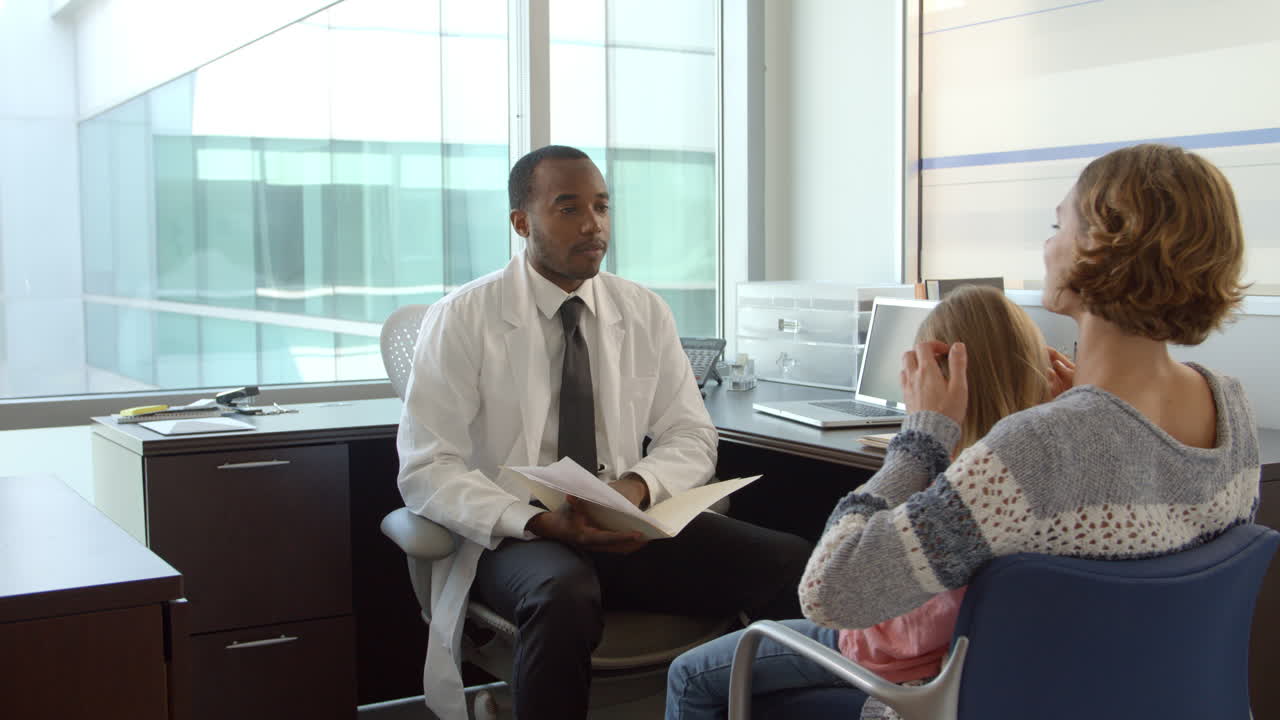 el pediatra se reúne con la madre y la hija en el hospital