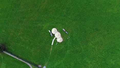 Aerial-view-of-large-3-peak-tipi-in-luscious-green-field