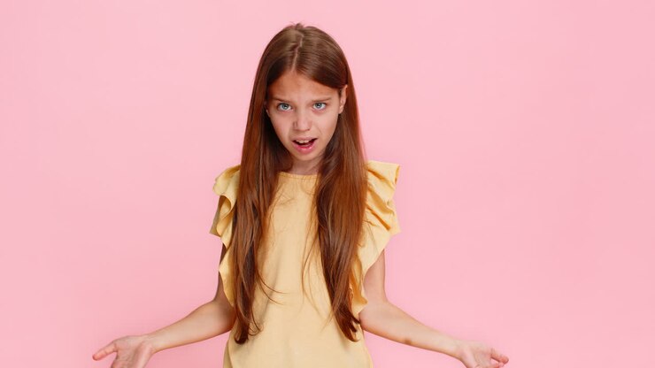 Bambina che alza le sopracciglia sorpresa, con un gesto che esprime stupore e domanda