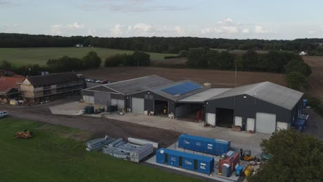 aerial footage farm yard in essex england large storage buildings drone tracking right to left