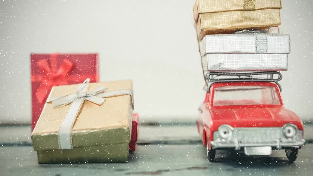 Modellino di auto rosso con regali sul tetto e neve che cade
