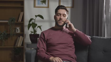 joven en casa recibiendo una llamada telefónica diciéndole que no ha tenido éxito en la entrevista de trabajo 3